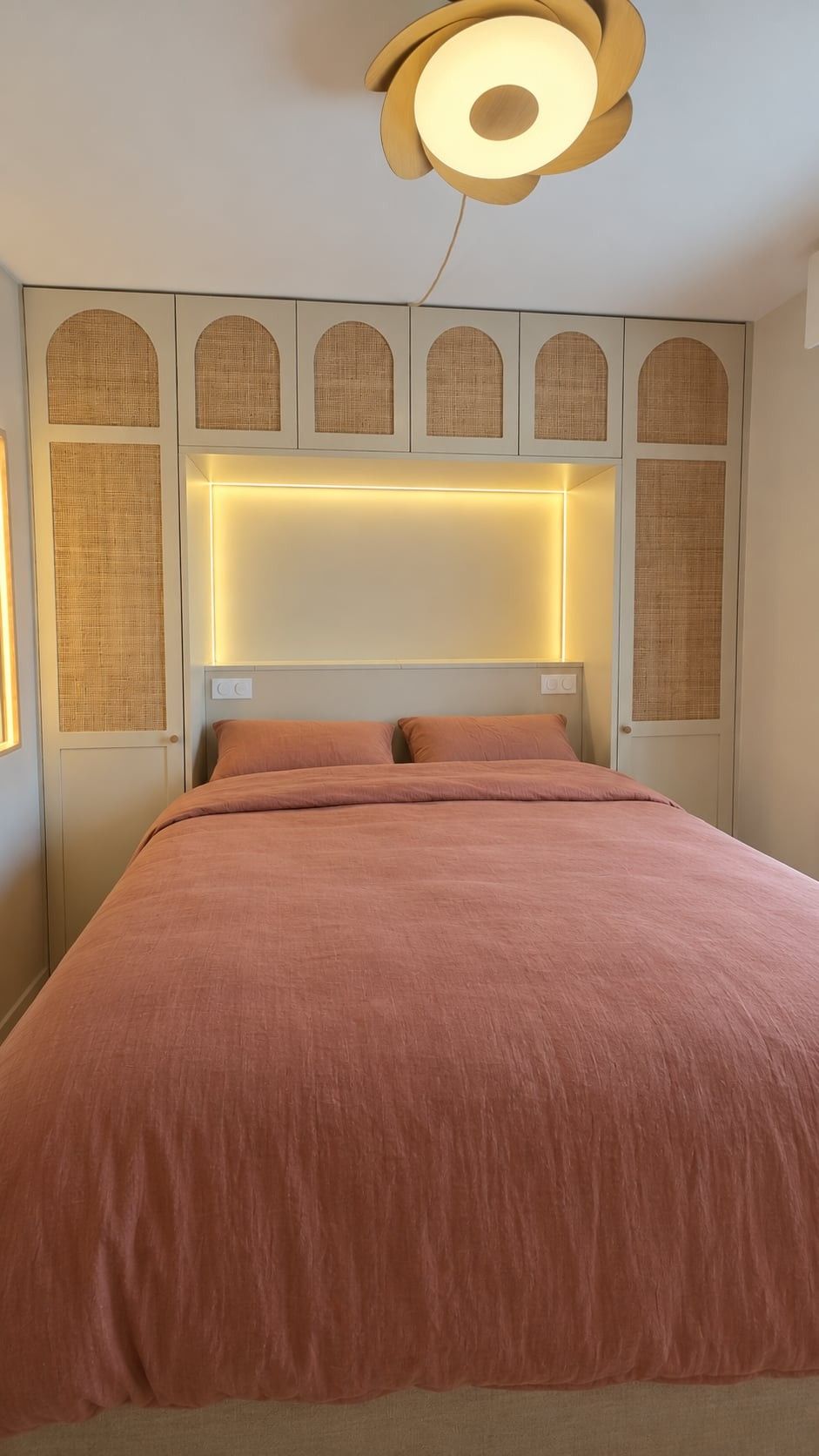 Placards autour du lit avec portes cannées en arche et niche éclairée au-dessus de la tête de lit