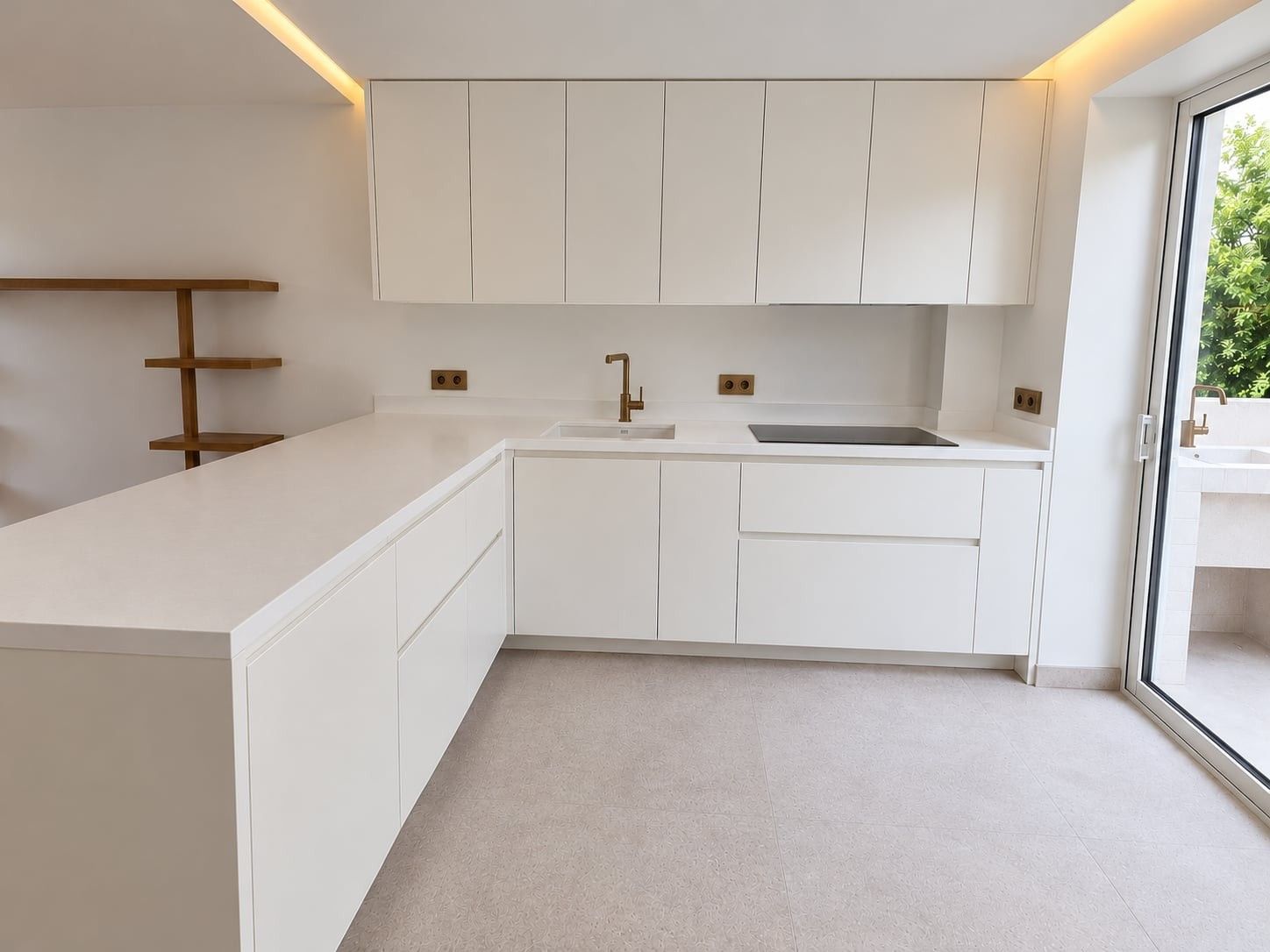 Cuisine blanche en L sans poignées, avec meubles hauts, plaque de cuisson et robinet doré