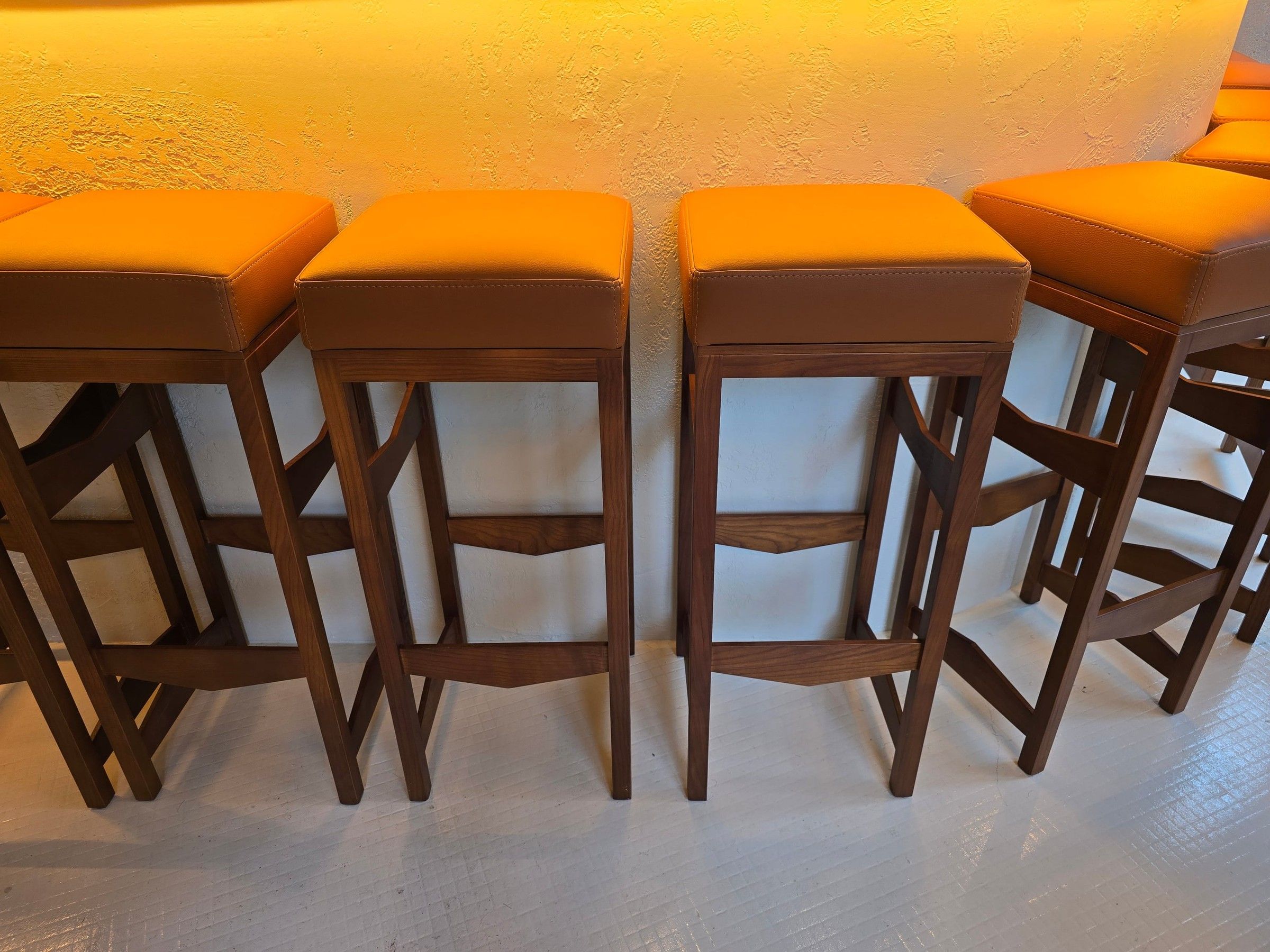 Tabourets de bar en bois teinté à entretoises, avec assise carrée garnie camel à surpiqûres
